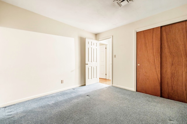 unfurnished bedroom with a closet and light carpet