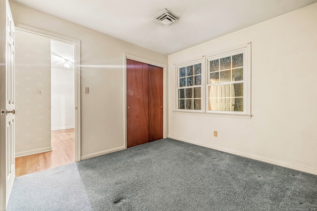 unfurnished bedroom with a closet and carpet flooring