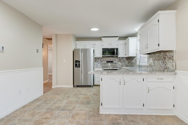 kitchen featuring appliances with stainless steel finishes, white cabinetry, and sink