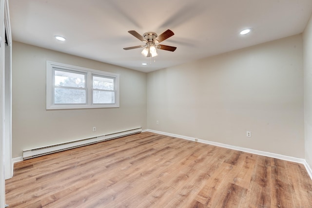 spare room featuring ceiling fan, light hardwood / wood-style flooring, and a baseboard heating unit