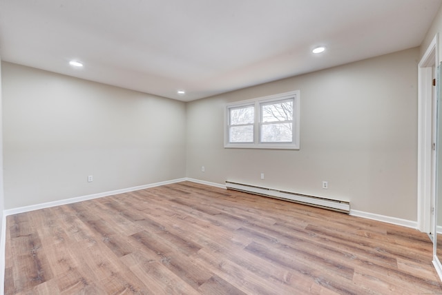 empty room featuring a baseboard radiator and light wood-type flooring