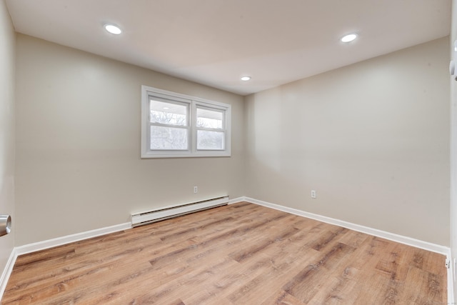 unfurnished room featuring light hardwood / wood-style flooring and a baseboard heating unit