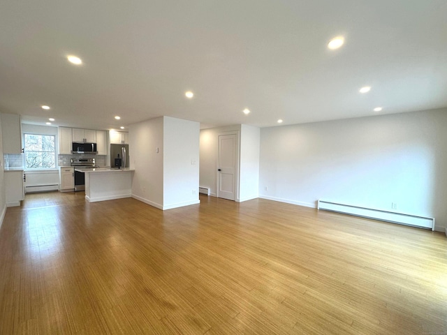 unfurnished living room with light wood-type flooring and baseboard heating