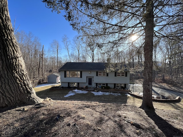 view of front of home with dirt driveway, an outbuilding, and entry steps