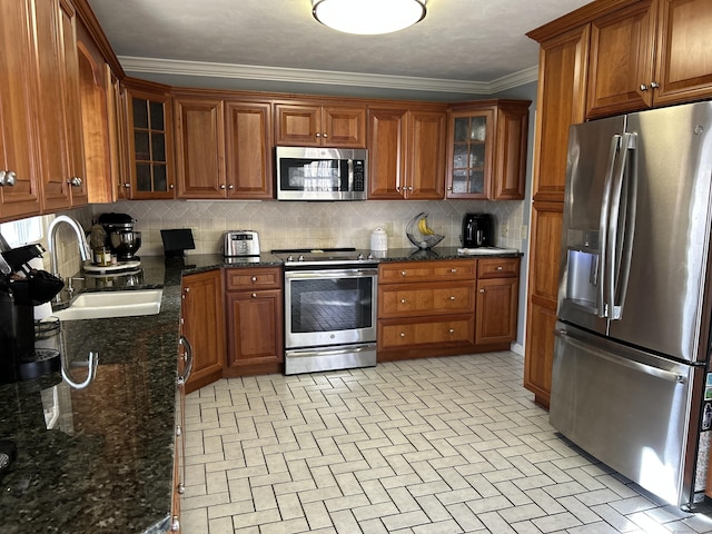 kitchen with brown cabinetry, decorative backsplash, stainless steel appliances, and a sink