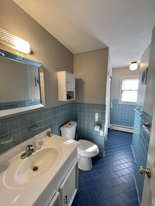 full bathroom featuring wainscoting, toilet, baseboard heating, vanity, and tile walls