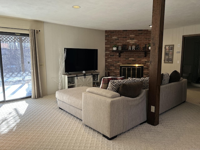 living room with a brick fireplace and light colored carpet