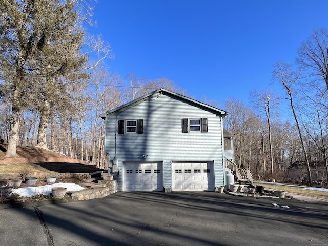 view of property exterior featuring driveway and an attached garage