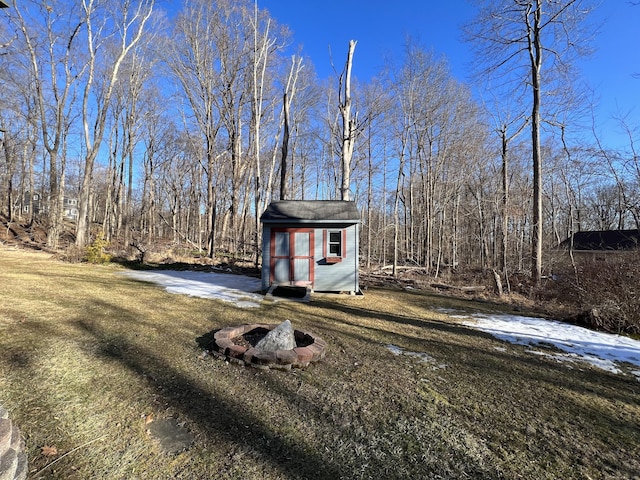 exterior space with an outbuilding, a fire pit, and a shed