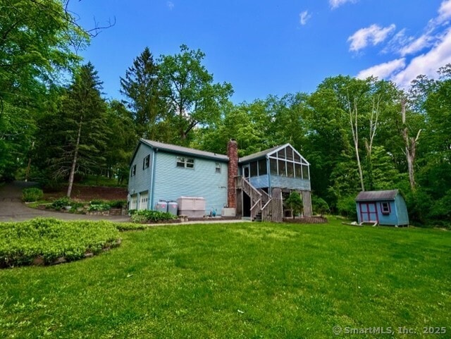 7 Varian Dr, Danbury, CT 06811 - rear view of property featuring a sunroom, a garage, a shed, stairs, and a yard