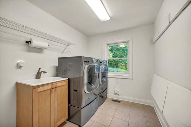 clothes washing area with cabinets, separate washer and dryer, sink, and light tile patterned floors