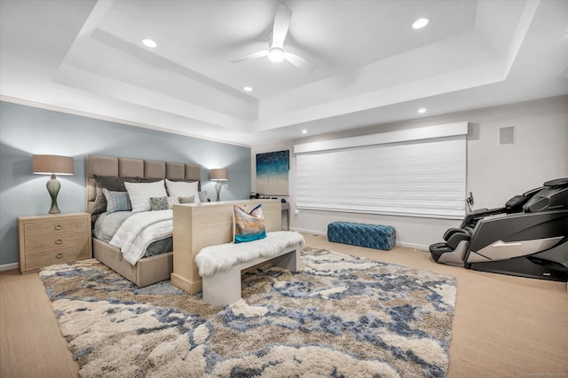 bedroom with a raised ceiling and ceiling fan