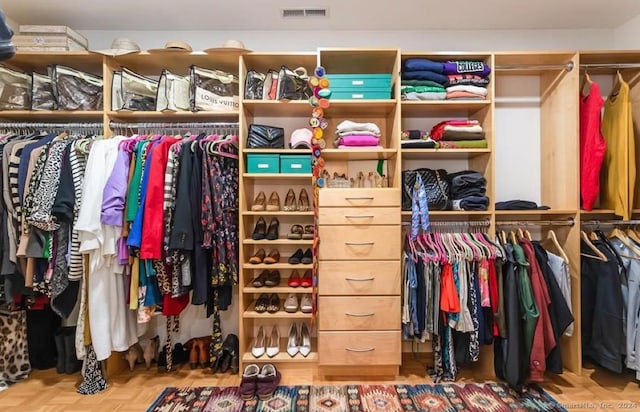 spacious closet featuring parquet floors