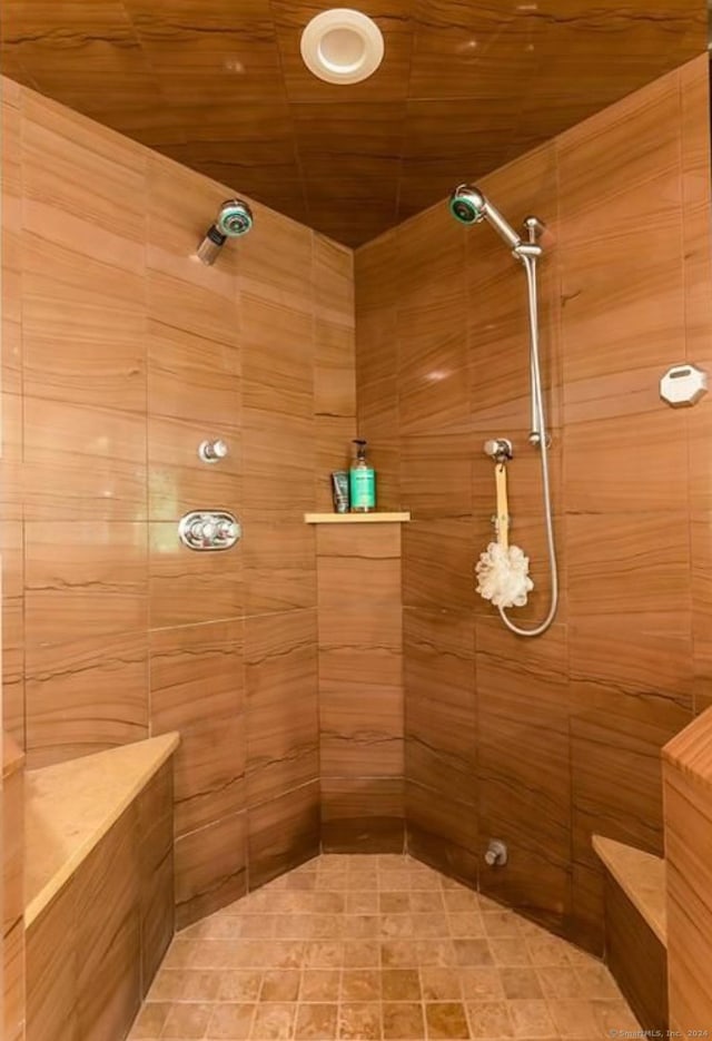 bathroom featuring a tile shower and wood ceiling