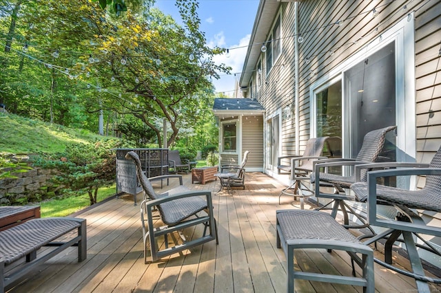 wooden terrace with an outdoor living space