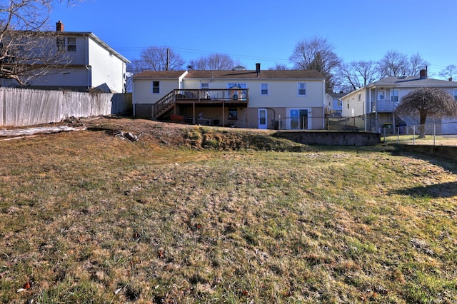 rear view of property featuring a deck and a yard