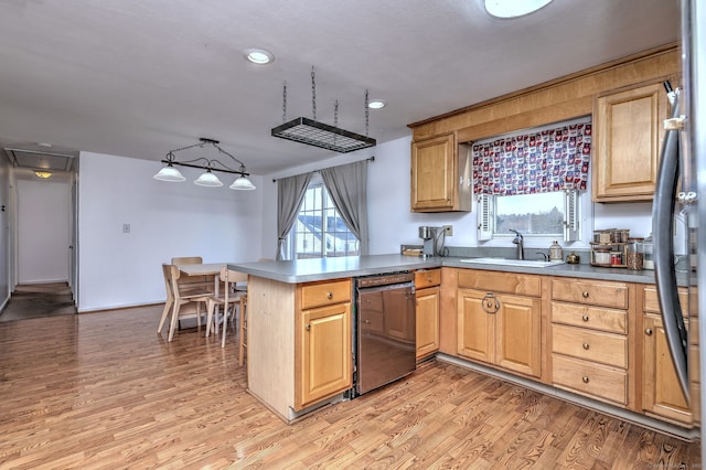 kitchen featuring dishwasher, sink, decorative light fixtures, light hardwood / wood-style floors, and kitchen peninsula