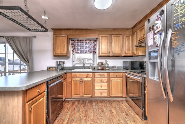 kitchen featuring kitchen peninsula, sink, exhaust hood, wood-type flooring, and black appliances