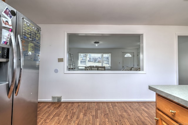 kitchen with stainless steel fridge and dark wood-type flooring