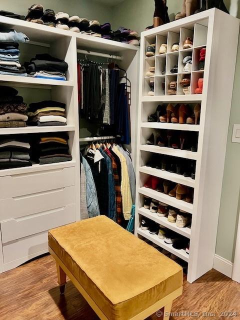 walk in closet with wood finished floors