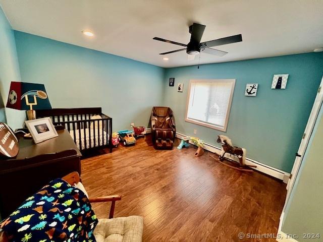 bedroom with a ceiling fan, baseboards, and wood finished floors