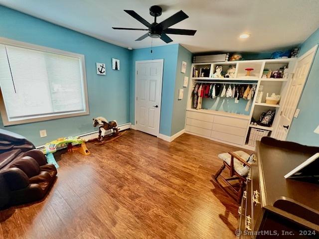 interior space featuring ceiling fan, baseboards, and wood finished floors