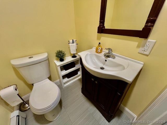 bathroom featuring baseboards, vanity, and toilet