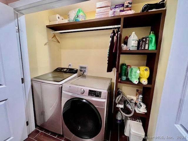 clothes washing area with laundry area, dark tile patterned floors, and independent washer and dryer