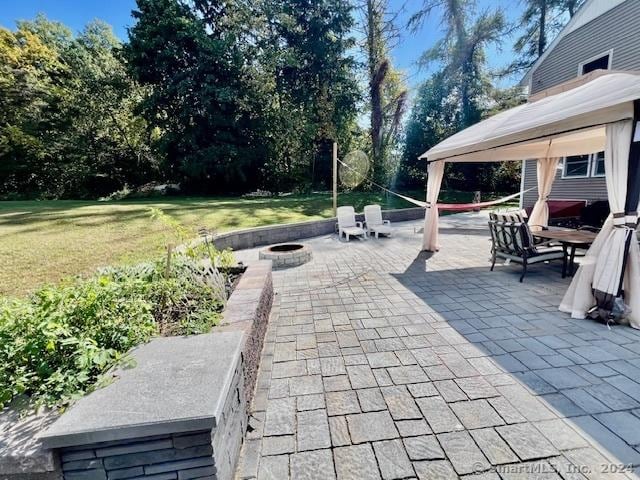 view of patio featuring an outdoor fire pit and a gazebo