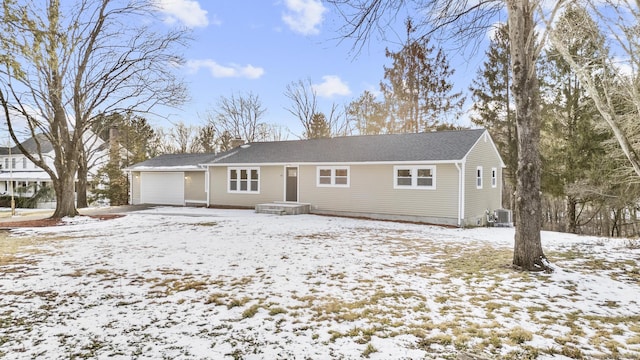 view of front of property with a garage and central air condition unit