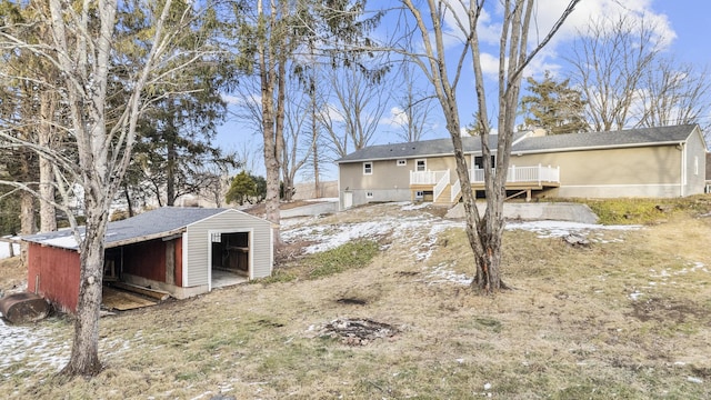 view of yard featuring an outbuilding, a wooden deck, and a garage