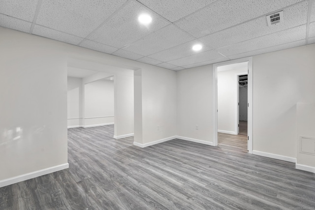 basement with a drop ceiling and hardwood / wood-style floors