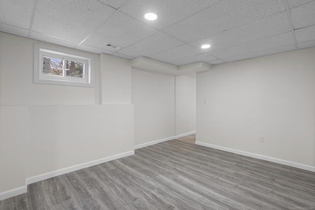 basement featuring hardwood / wood-style flooring and a paneled ceiling