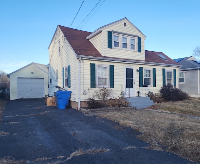 view of front of house with a garage and an outbuilding