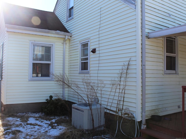 snow covered property featuring central AC unit