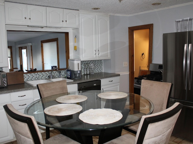 dining room with ornamental molding and a textured ceiling