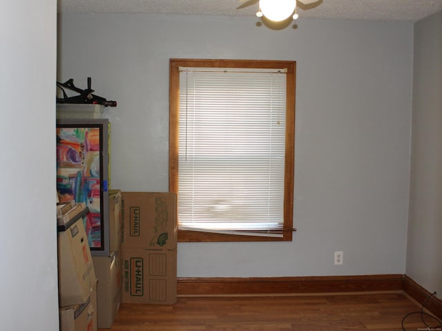 interior space with ceiling fan, hardwood / wood-style floors, and a textured ceiling