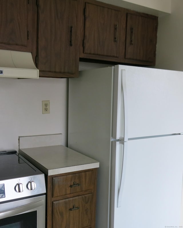 kitchen featuring stainless steel range with electric cooktop, white refrigerator, and extractor fan