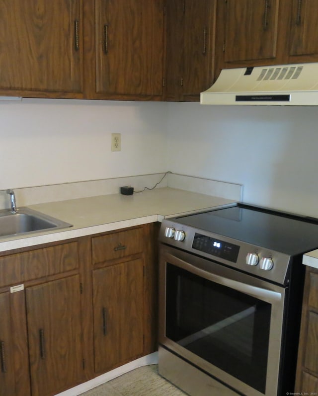 kitchen with exhaust hood, stainless steel electric stove, and sink