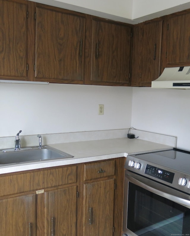 kitchen featuring ventilation hood, electric range, and sink