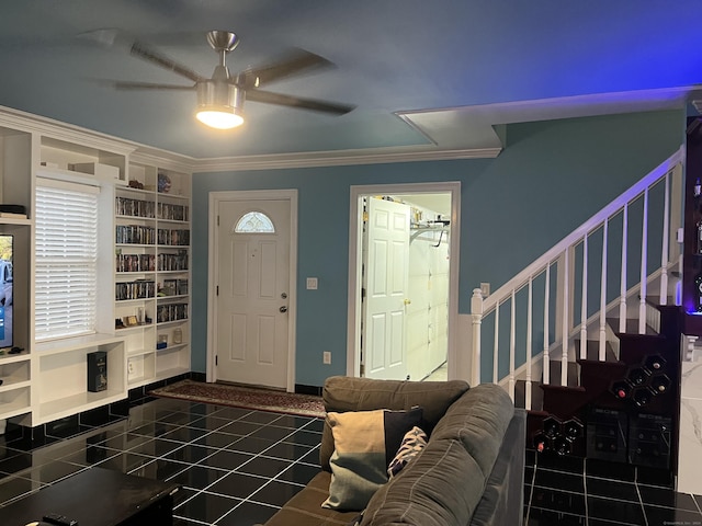 tiled foyer featuring ceiling fan and crown molding