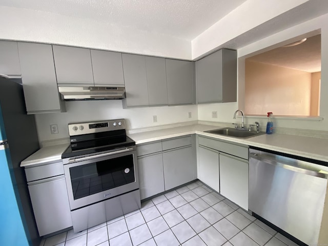 kitchen featuring gray cabinetry, sink, stainless steel appliances, a textured ceiling, and light tile patterned floors