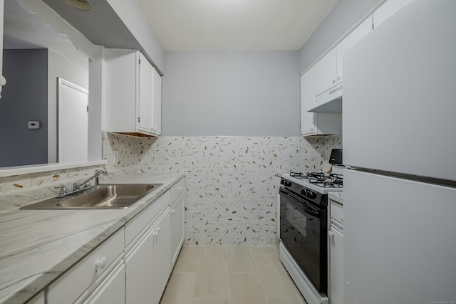 kitchen with a textured ceiling, white appliances, sink, exhaust hood, and white cabinets