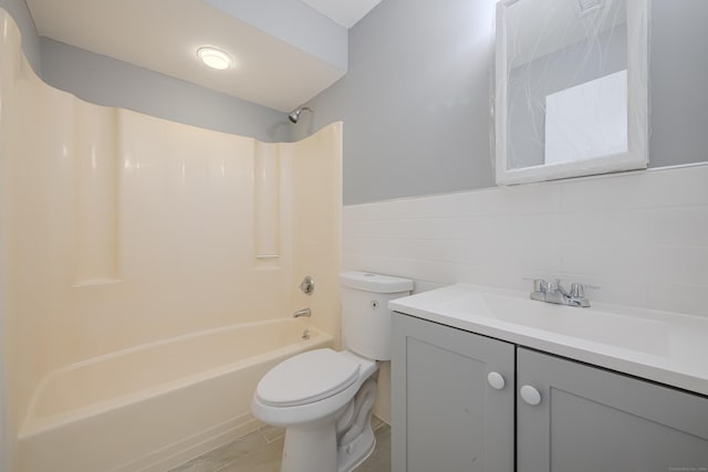 full bathroom with shower / washtub combination, tile walls, vanity, and toilet