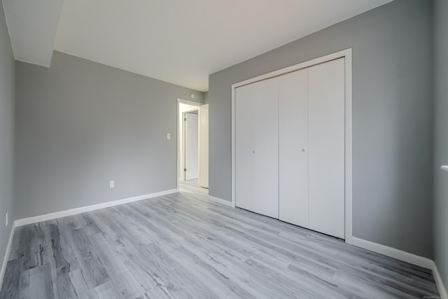 unfurnished bedroom featuring light wood-type flooring and a closet