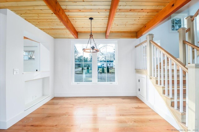 unfurnished dining area featuring beamed ceiling, a notable chandelier, wood ceiling, and light hardwood / wood-style flooring