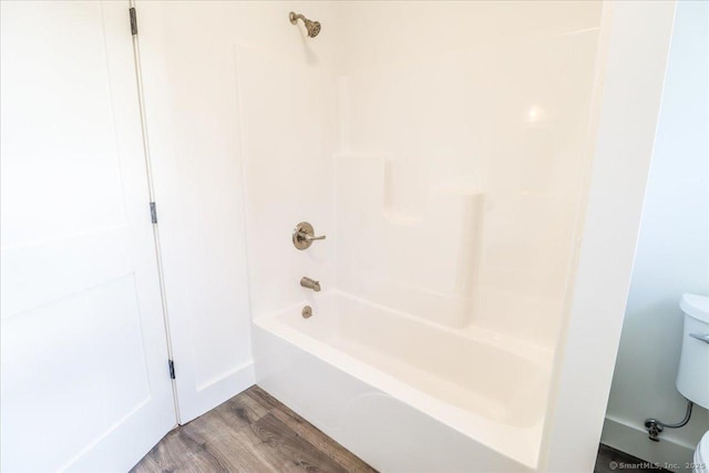 bathroom with shower / tub combination, hardwood / wood-style floors, and toilet