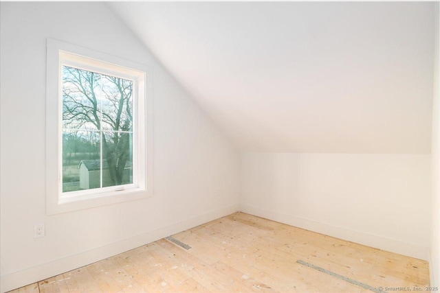 bonus room with light wood-type flooring and vaulted ceiling