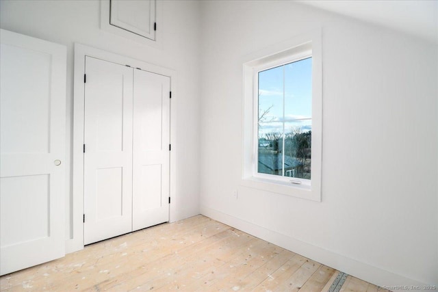 unfurnished bedroom with light hardwood / wood-style floors and a closet