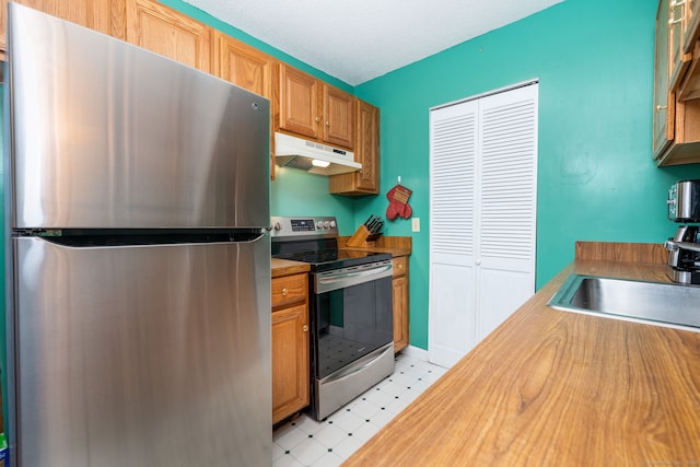 kitchen with sink, stainless steel appliances, and a textured ceiling